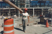  A female construction worker lifts a beam on a job site.