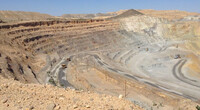 An open pit copper mine with heavy equipment. 