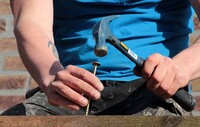 person hammering a nail