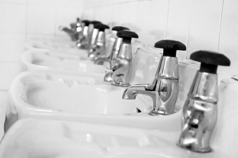a row of bathroom faucets