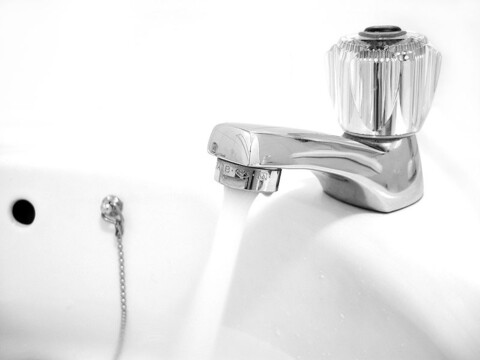 Photo of an open sink tap with water running