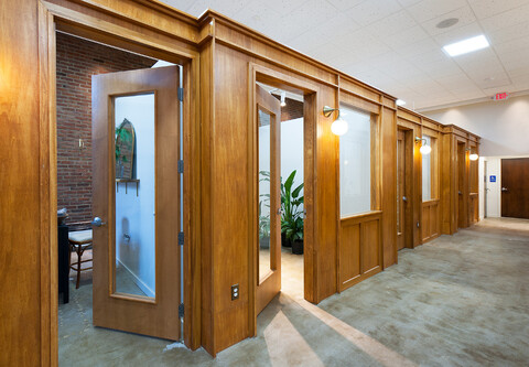 Doors Unhinged reclaimed wood doors are open into a carpeted office.