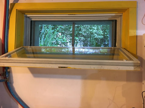 Photo of an open basement hopper window 