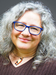 white woman with curly, shoulder-length gray hair